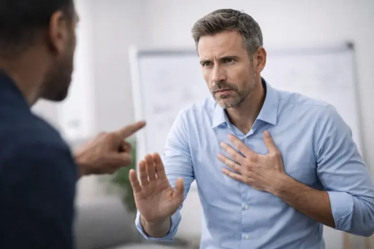 Man reageert defensief tijdens feedbackgesprek in kantooromgeving